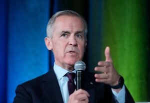 ۱) عکس مارک کارنی در یک نشست رسمی یا هنگام سخنران